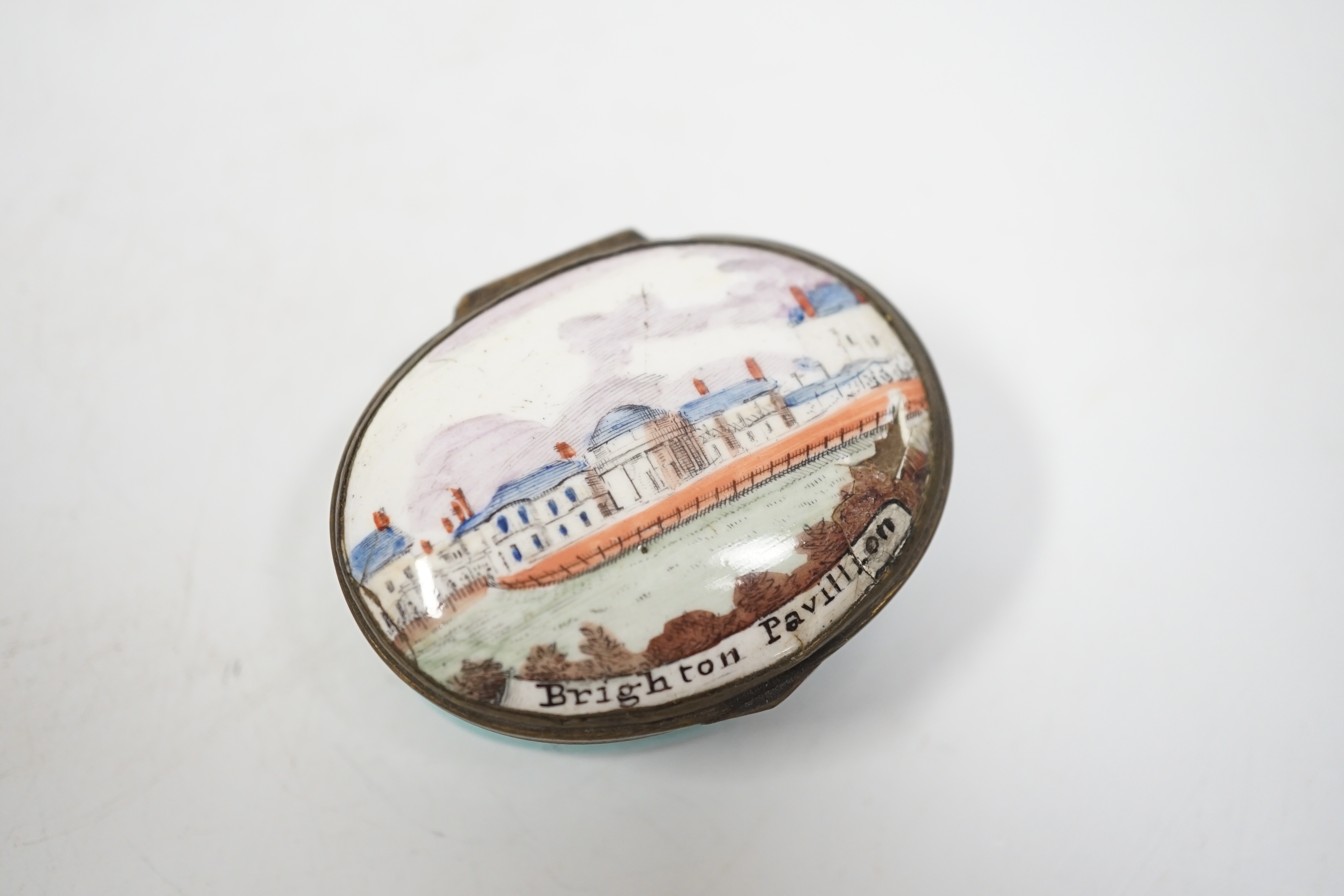 A rare South Staffordshire enamel patch box with an early view of Henry Holland’s Brighton pavilion, c.1800, 5 cm across, a/f